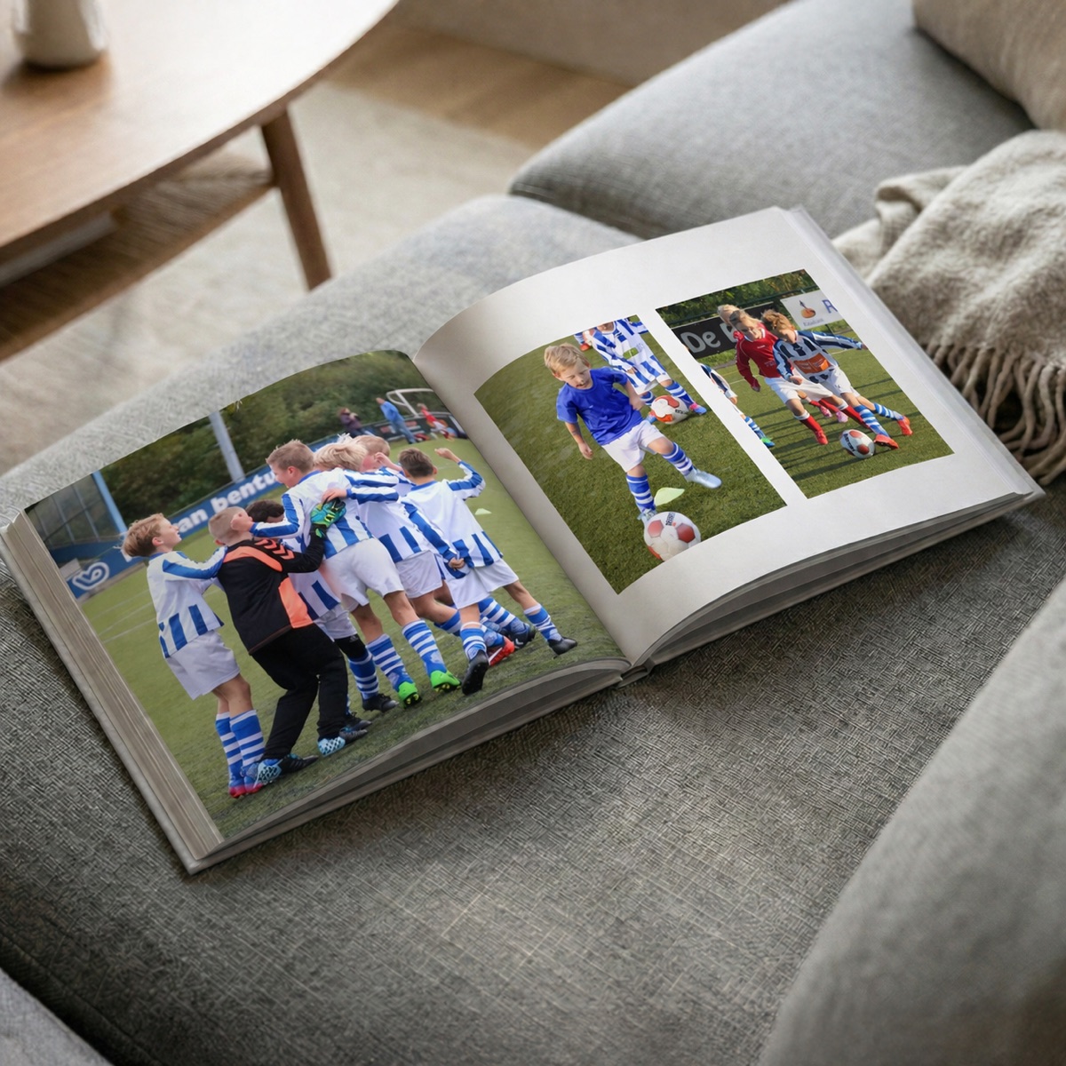 Geopend voetbalfotoboek met teamfoto's op een bank
